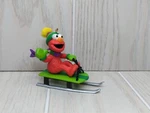 Sesame Street Elmo On Green Sled Wearing Hat Scarf 2001 Christmas Ornament. Fixed Price $9.87.